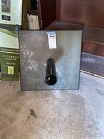 Square metal patio umbrella stand base viewed from above, showing square flat textured surface with a black umbrella holder tube in the center.