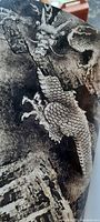 Close-up of a page showing a traditional Chinese ink-style dragon painting in grayscale with detailed scales and mountainous background.