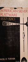 Front cover showing title, author, and silver flatware illustration