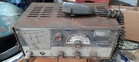 Front and top view of the rusty metal CB radio base unit with microphone on top.