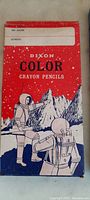 Close-up of the Dixon colored crayon pencils box showing vintage space-themed graphics featuring astronauts on a lunar surface.
