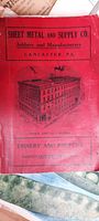 Front cover of the red product catalog featuring company name, location (Lancaster, PA), and an illustration of the company building.