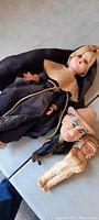 Three antique dolls: weighted eyed nun doll, stand-up man figure, and Indian doll, resting on a surface.