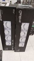 Two boxed Artika LED vanity lights shown upright, highlighting the brand and four round LED lights per fixture on the packaging.