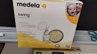 Box showing Medela Swing breast pump with product image and brand.