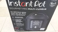 Front view of the Instant Pot Gourmet Pro Multi-Cooker box showing product name, features, and image of the cooker.