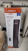 Box of Lasko Elite Collection Digital Ceramic Tower Heater, upright device for home heating.