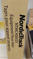Box side showing NordicTrack logo and model number NTMC408020 with bilingual labeling for equipment floor mat.