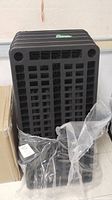 Stacked black plastic shelving panels in packaging
