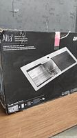 Photo of the box showing the Alta brand Kitchen Work Centre Stainless Steel Single Bowl Sink Kit including accessories with product image and branding.