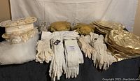 Full view of the lot laid on a black surface showing bridal gloves, headpieces, gold bows, and veil.