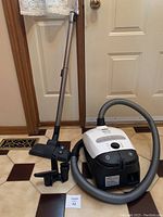 Overview of vacuum canister, hose, telescopic wand, floor nozzle and attachments