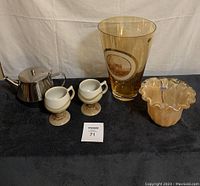 Full lot showing stainless steel teapot, two Capilano pottery cups, tall amber Murano glass vase, and smaller amber ruffled glass vase