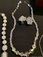 Close-up of clear faceted bead necklace with matching clip-on earrings.