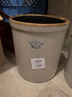Front view of the vintage stoneware crock showing the blue crown logo with '4' capacity marking and cream exterior glaze.