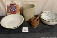 Items showing enamel wash basin, vintage crock, wooden mortar/pestle, retro bowls, and cookbooks.