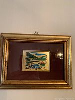 Gold leaf frame with dark mat, miniature painted artwork showing a car in a landscape