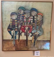 Front view of one print showing five characters riding bicycles dressed in colorful striped clothing, framed in copper-tone frame.