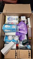 Boxed lot showing multiple packages of new lightbulbs, including GE Long Life 43 and LED Edison bulbs.