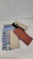 Photo of group lot showing various cloth placemats in different colors and patterns, folded and stacked