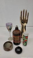 Front view of group showing hand sculpture, goblet, vase, ink bottle, and ceramic items