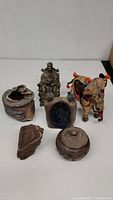 Front view of six decorative items including Buddha statue, fabric elephant, stone and pottery pieces