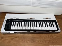 Full view of the Alesis Q49 keyboard on its original box, showing the complete 49 keys and general condition.