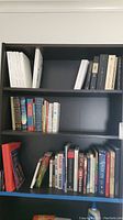 Bookshelf with various books in Spanish and English, showing paperback and hardcover types