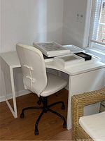 Full view of white office chair positioned in front of L-shaped white desk showing overall condition and appearance.