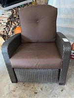 Front view of outdoor recliner chair showing brown seat and back cushions with dark brown woven wicker frame.