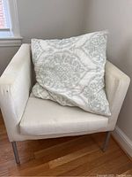 Armchair with patterned cushion on seat showing rest of chair details