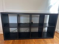 Full view from front showing structure with 8 cubby compartments and black finish.