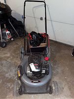 Full view of lawn mower showing deck, handlebars, and front wheels.