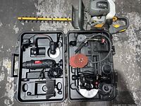 Photo showing Craftsman rotary tool and attachments in carrying case alongside Ryobi gas hedge trimmer