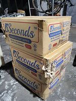Stack of two cardboard boxes labeled '5 Seconds Disinfectant Wipes' with visible cat scratch damage on corners and edges.