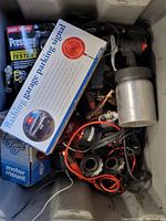 Variety of automotive hardware items including flashing parking signal, metal canister, wires and small parts