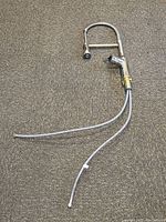 Full view of Miseno kitchen faucet with attached hoses laid on carpet, showing overall condition and structure.