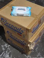 Three stacked cardboard boxes labeled '5 Seconds Disinfectant Wipes' with one 5 Seconds wipe package on top, showing condition and packaging details.