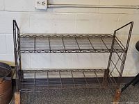 Front view of the brown wire shelf showing two storage levels and wire grid construction.