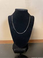 Front view of the sterling silver chain necklace displayed on a black jewelry stand.
