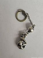 Photo of sterling silver mermaid keychain showing the key ring, connecting chain, and mermaid charm in profile.