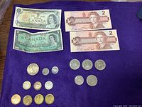 Photo showing Canadian $1 and $2 bills and a variety of Canadian coins on a purple background.