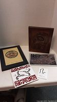 Overview photo showing all items in the lot including wood carved plaque, framed print, smaller prints and tiles.