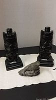 Front view of both totem bookends and gray stone seal sculpture on white lace cloth
