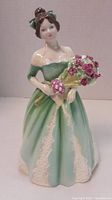 Front view of Royal Doulton figurine of a woman in green dress holding flowers