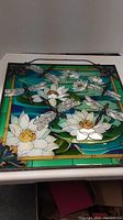 Full view of stained glass panel showing dragonflies, water lilies, lily pads, and colorful bordered background.