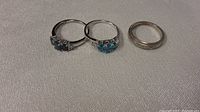Three rings displayed side by side on neutral fabric