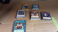 Multiple stacks of Yugioh trading cards organized on a flat surface showing front card faces and edges.