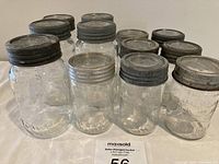 12 vintage Crown Mason jars with original metal lids, shown in a box, various sizes visible.