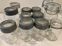 Full group of 12 vintage Mason jars including Crown, Corona, and Safety Close types with original lids visible.